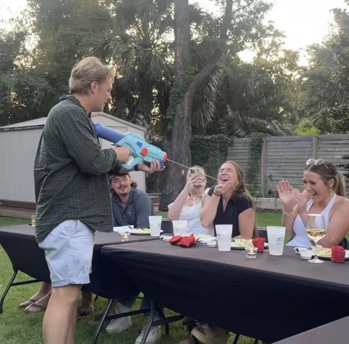Guests laughing during a backyard party game