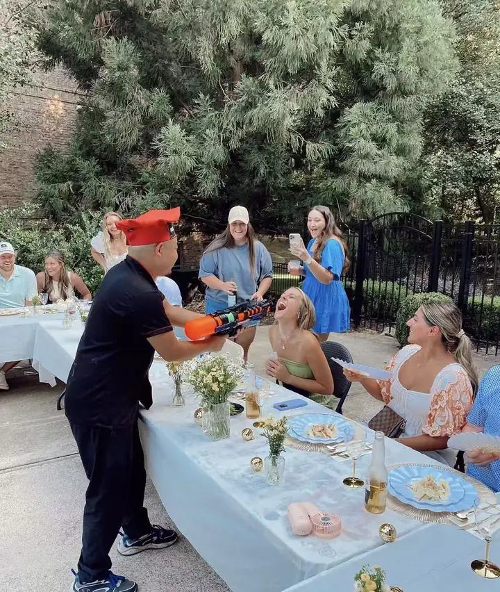 Chef entertaining guests at an outdoor hibachi party